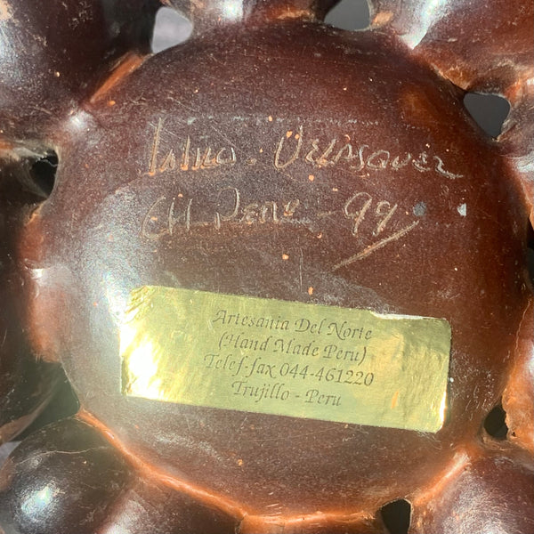 Chulucana woman sitting among pots